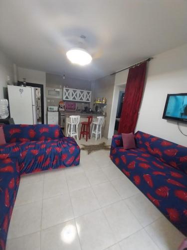 a living room with a red couch and a kitchen at Tavira شاليه in Ras Sedr