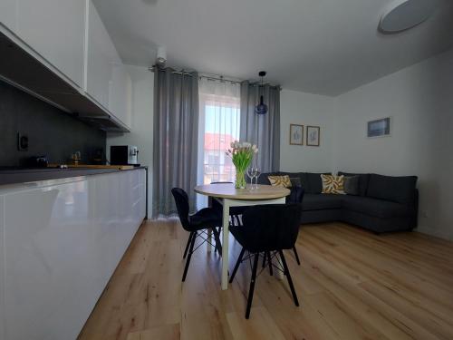 Una cocina y una sala de estar con mesa y sillas. en Apartament u Moniki, en Międzywodzie