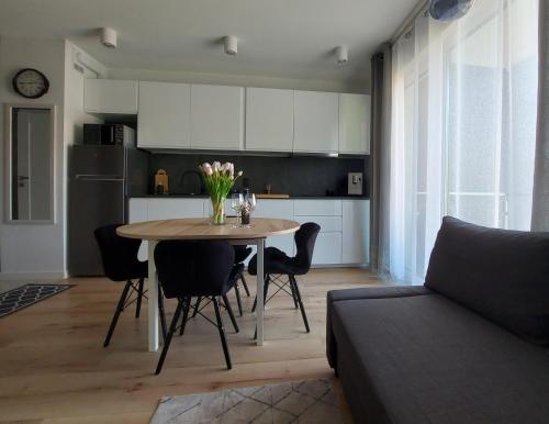 cocina y comedor con mesa y sofá en Apartament u Moniki, en Międzywodzie