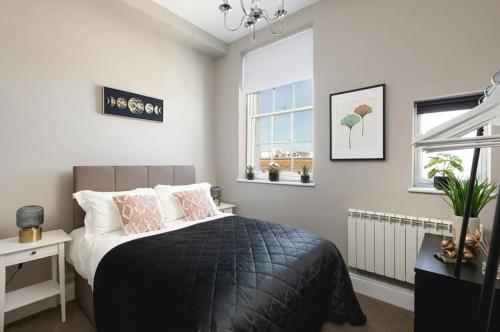 ein Schlafzimmer mit einem Bett mit Kissen und einem Fenster in der Unterkunft Brighton Lanes Cosy One Bedroom Apartment in Brighton & Hove