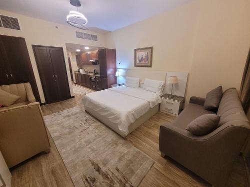 pokój hotelowy z łóżkiem i kanapą w obiekcie Lotus Apartments w mieście King Abdullah Economic City