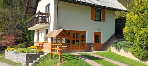 Holiday Home Forest Peace, Lavrovec في Hlevni Vrh: منزل صغير أمامه هيكل لعب
