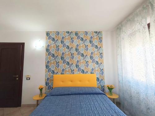 a bedroom with a blue bed with a yellow head board at Affittacamere Center Room in Tortolì