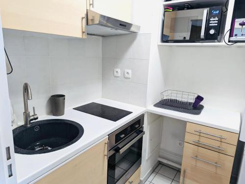 a small kitchen with a sink and a microwave at Studio Ligne 7 : Vision d'avenir in Le Kremlin-Bicêtre