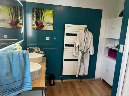 La salle de bains est pourvue d'un peignoir blanc accroché au mur. dans l'établissement Grande maison de 152 m² /6 pers., à Salles