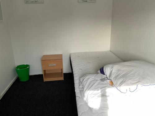 ein kleines Zimmer mit einem Bett und einem Nachttisch in der Unterkunft B&B Ire in Ilulissat