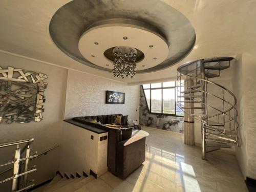 ムレ・ブッスルアムにあるVilla Serenade 3 etageの階段とシャンデリアが備わる広い客室です。