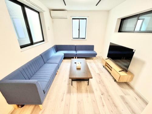 a living room with a blue couch and a table at 包棟3房別墅 直達上野2分 可住8人 適合團體家庭旅遊 in Tokyo