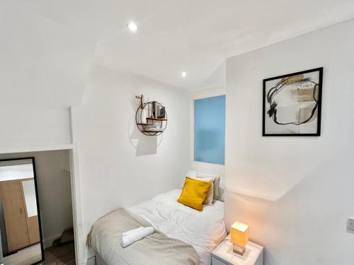 a bedroom with a bed with a yellow pillow at 7-mins to Central London, Premium 3-bedroom Getaway, Sleeps 7, Free Parking in London
