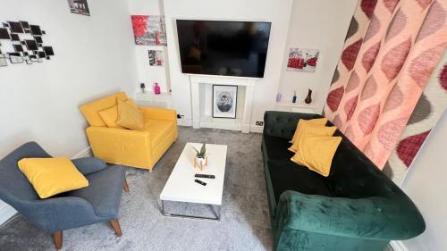 a living room with two chairs and a tv at Seymour Place, Hyde Park, Edgware Road London Apartments in London