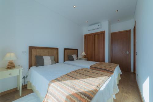 a bedroom with a large bed with a striped blanket at Casas de Campo em Estoi by Garvetur in Estói