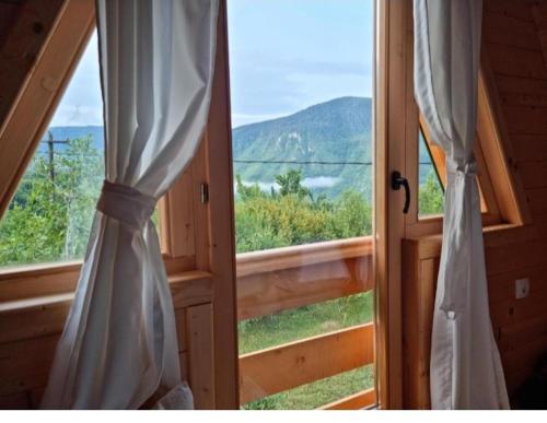 an open door with a window with a view at Etno house Bajka in Žabljak