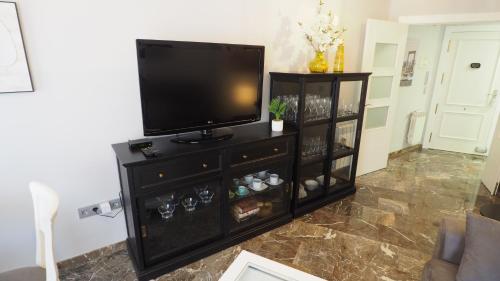 a black entertainment center with a flat screen tv at Apartamento en centro ciudad con garaje y aire acondicionado in Albacete