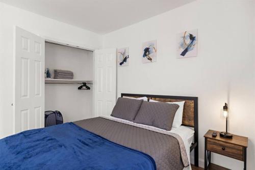 a bedroom with a blue bed and a white wall at Comfy Cozy retreat - NYC & NWK w free parking in Bayonne