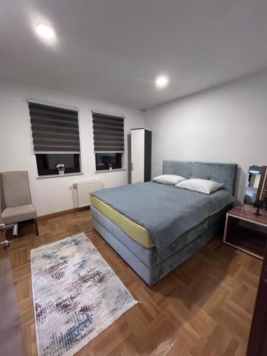 um quarto com uma cama, uma mesa e 2 janelas em Apartments Divanhana em Kiseljak