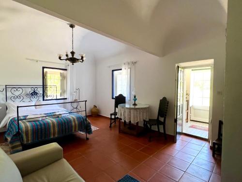 ein Wohnzimmer mit einem Bett und einem Tisch in der Unterkunft Qta Casa Seleiras - Guest House in Évora