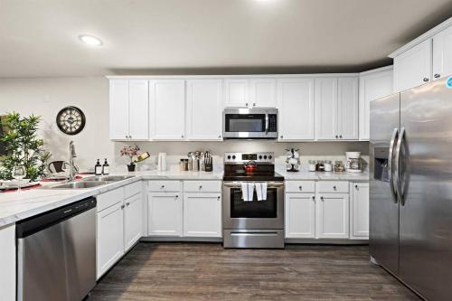 a kitchen with white cabinets and stainless steel appliances at Family & Traveler Haven - NYC & NWK w/free parking in Newark