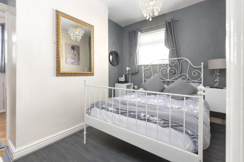 a childs bedroom with a white crib and a mirror at Sunnyside house in Blackpool