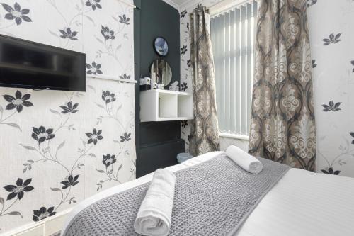 a bedroom with a bed and a tv on the wall at Sunnyside house in Blackpool