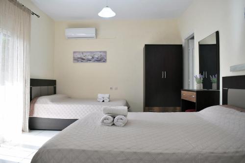 ein Schlafzimmer mit zwei Betten, auf denen Handtücher liegen in der Unterkunft Fotini's Studios 1 in Toroni