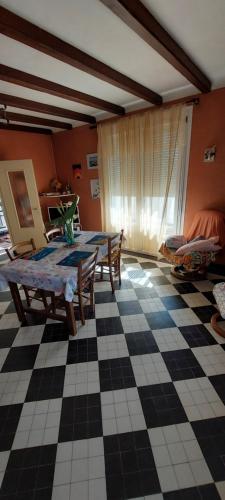 un salon avec une table et un sol en damier dans l'établissement Maison avec garage proche de la plage, à Les Sables-dʼOlonne