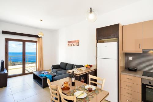 a kitchen and living room with a table and a refrigerator at Livaniana Panoramic View House 1 in Livanianá
