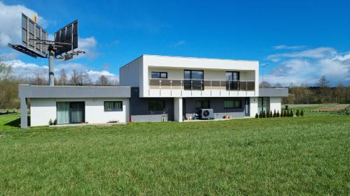 a white house with a large grass field at APARTMÁNY I&V - Adults only in Plzeň