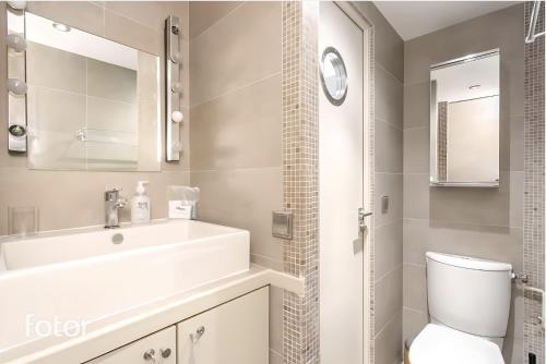 une salle de bain avec un lavabo blanc et des toilettes dans l'établissement Suite Du Lion/AC Historic Flat, Marais, 4-5 Guests, à Paris