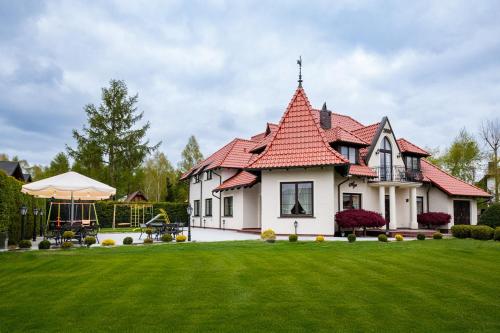 a large white house with a red roof at Willa Aga in Dębki