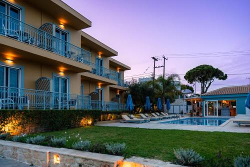 a villa with a swimming pool at dusk at Memories Apartments in Laganas