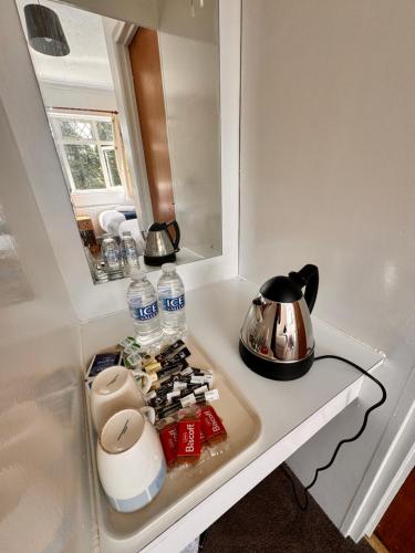 a kitchen counter with a tea pot and a tea kettle at High Trees Guest House Gatwick in Horley