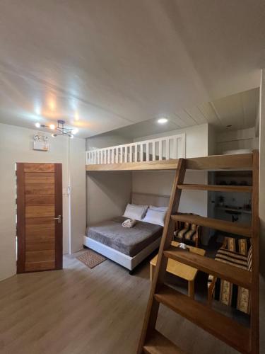 a small room with a bunk bed and a ladder at Balay na Bato in Legazpi