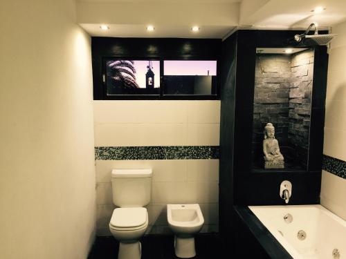 a bathroom with a toilet and a sink and a tub at Bali Hotel Boutique in San Gregorio de Polanco