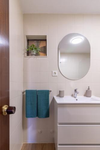 a white bathroom with a sink and a mirror at AH El Corazón de Corrida VUT4786AS in Gijón