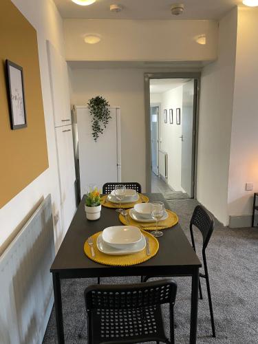 a black table with plates on it in a room at Westm-3 Bdrm 3 bathrooms 1 EnSuite Fab for contractors Free Parking and Wi-Fi in Gateshead