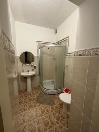 a bathroom with a shower and a toilet and a sink at Дом Жени и Люды in Zhabagly