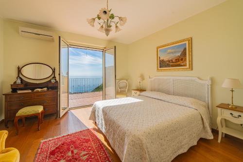 a bedroom with a bed and a view of the ocean at Sea View Villa Taormina in Taormina