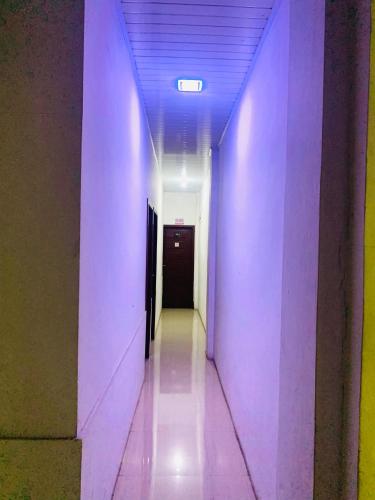 un pasillo con paredes púrpuras y un pasillo con puerta en SEUNIA HOTEL en Lamnyong
