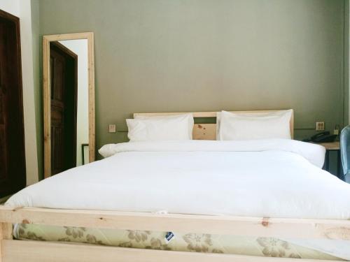 a bedroom with two beds with white sheets at BONO MOTELS in Nārān