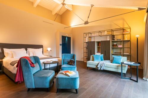 a bedroom with a bed and a couch and a chair at Le Cattedrali Relais by Laqua Collection in Asti