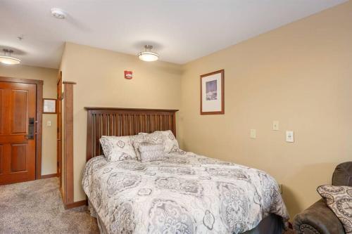 a bedroom with a bed with a comforter on it at Allegheny222, Hot Tub,Pool,Ski InOut,Village in Snowshoe