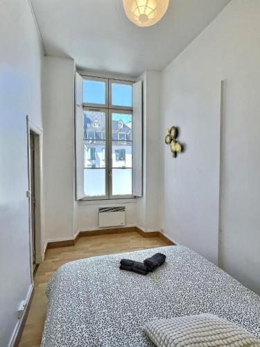 une chambre avec un lit et une grande fenêtre dans l'établissement WonderHost, les volumes de Margot en hypercentre, à Pau