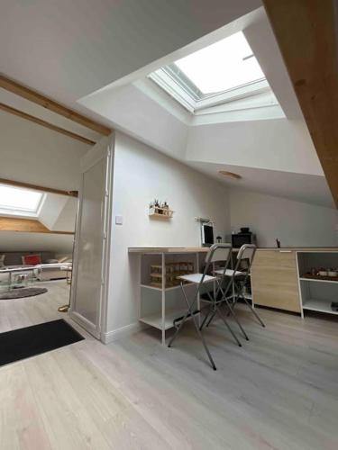 une chambre avec des chaises, une table et une lucarne dans l'établissement Komm a la Maison, à Yutz