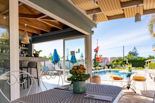 a patio with a table and chairs and a swimming pool at Memories Apartments in Laganas