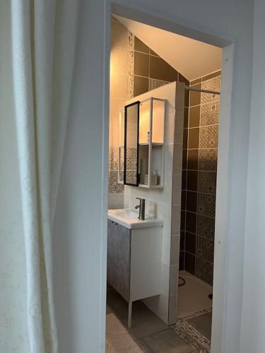 une salle de bain avec un lavabo et un miroir dans l'établissement Komm a la Maison, à Yutz