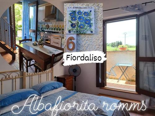 a bedroom with a bed and a table and a kitchen at Affittacamere Albafiorita in Castiglione dʼOrcia