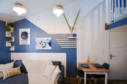un salon avec un mur d'accent bleu dans l'établissement La Kalipso H24, Atypique,Por,Plage,Fibre,Netflix, à La Seyne-sur-Mer
