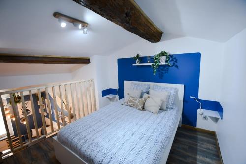 une chambre avec un lit avec un mur bleu dans l'établissement La Kalipso H24, Atypique,Por,Plage,Fibre,Netflix, à La Seyne-sur-Mer