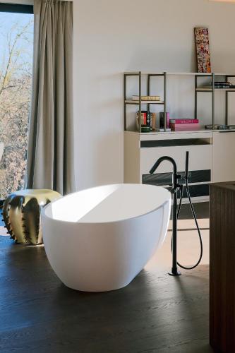 a large white bath tub in a room with a window at Le Cattedrali Relais by Laqua Collection in Asti