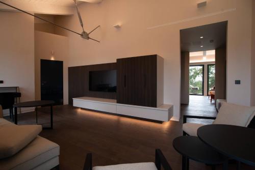 a living room with a couch and a tv on the wall at Le Cattedrali Relais by Laqua Collection in Asti